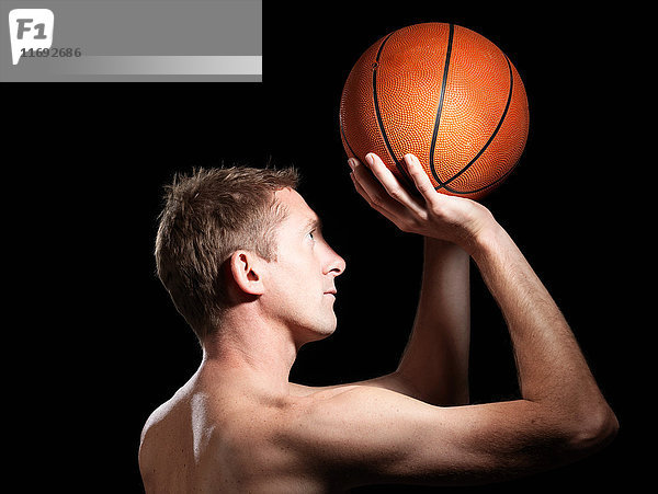 Halb bekleideter Basketballspieler vor schwarzem Hintergrund