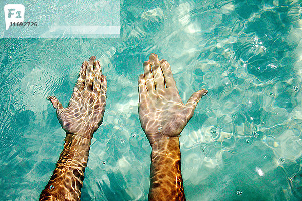 Hände unter tropischem Wasser