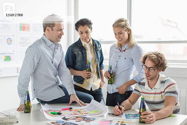 Bürokollegen besprechen kreative Pläne auf dem Schreibtisch