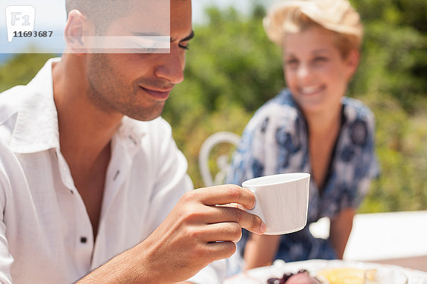 Mann trinkt Tasse Kaffee bei Tisch