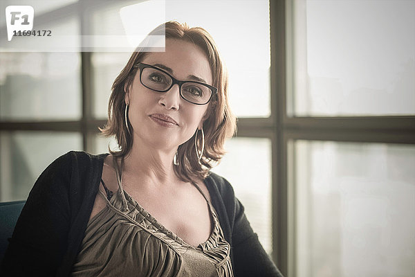Porträt einer reifen Frau mit Brille  die in die Kamera schaut