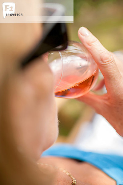 Frau trinkt ein Glas Wein im Freien