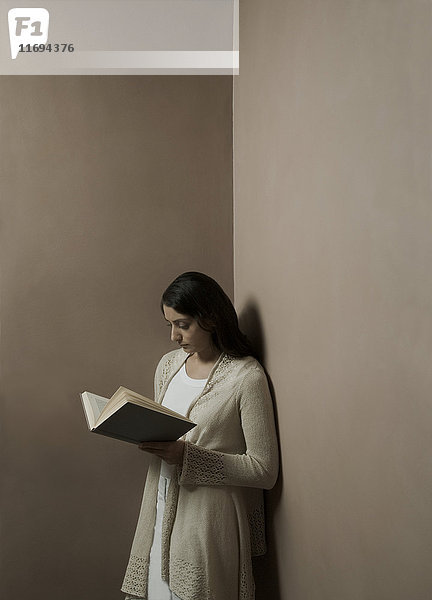 Frau liest Buch in einer Ecke des Raumes