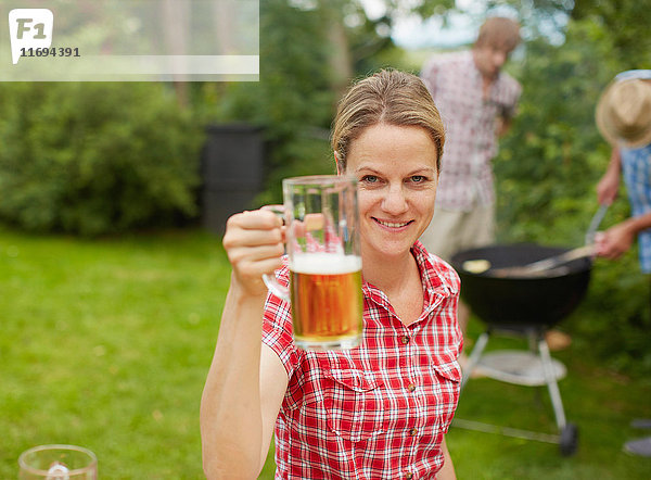 Frau hält Bierkrug im Freien