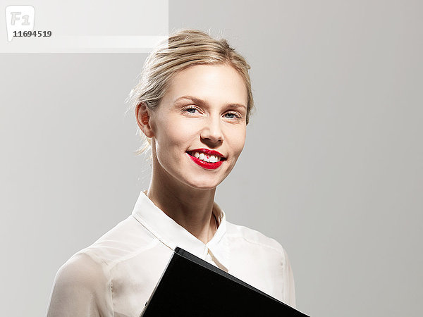 Lächelnde Frau mit Lippenstiftflecken auf den Zähnen  Studioaufnahme
