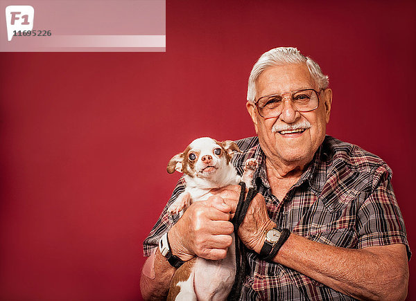 Älterer Mann hält kleinen Hund