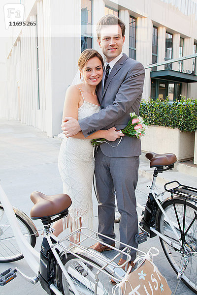 Porträt eines jungen frisch verheirateten Paares mit Fahrrädern
