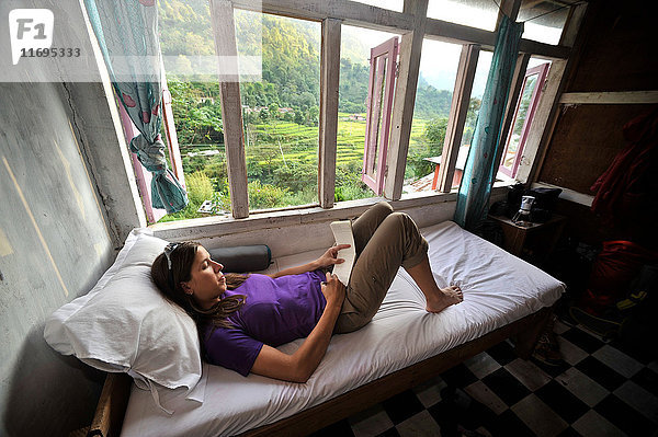 Frau entspannt sich in ihrem Zimmer in einem Teehaus  Bhulbhule  Nepal