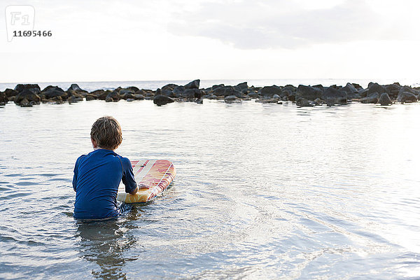 Junge im Meer mit Bodyboard  Kauai  Hawaii  USA