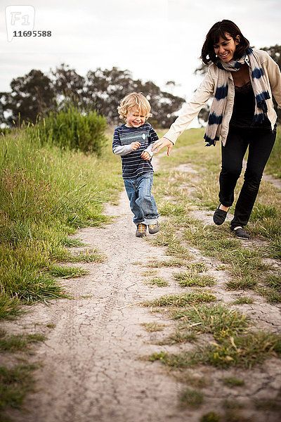 Mutter und kleiner Sohn laufen auf Feldwegen