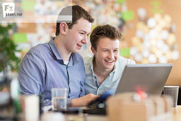 Junge Männer arbeiten am Laptop im Kreativbüro
