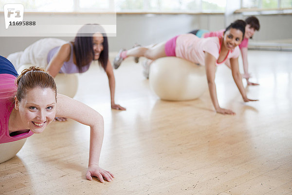 Frauen auf Gymnastikbällen im Sportunterricht