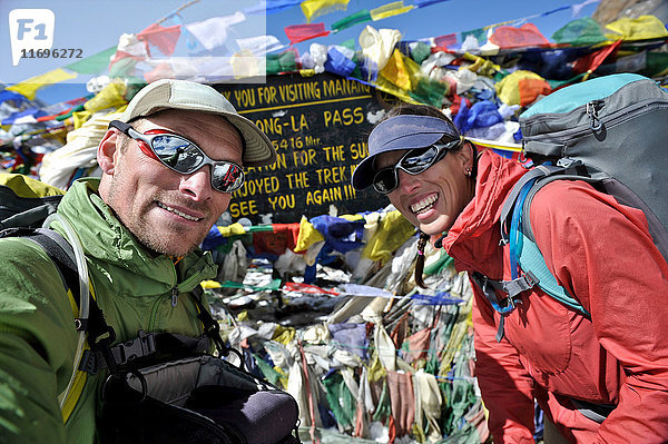 Trekker schauen in der Nähe von Gebetsfahnen in die Kamera  Thorung La  Nepal