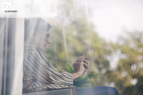 Seitenansicht der älteren Geschäftsfrau mit digitalem Tablett im tragbaren Bürowagen