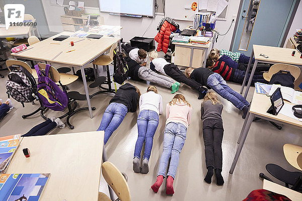 Hochwinkelansicht der Schüler in Brettlage im Klassenzimmer