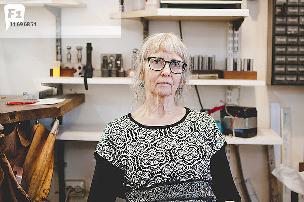 Porträt der selbstbewussten Seniorin in der Schmuckwerkstatt