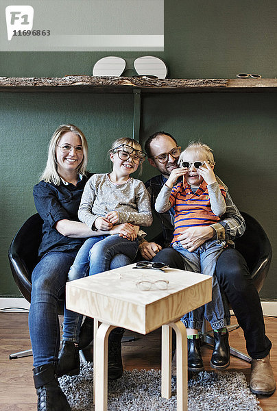 Volle Länge der glücklichen Familie in der Brillenwerkstatt