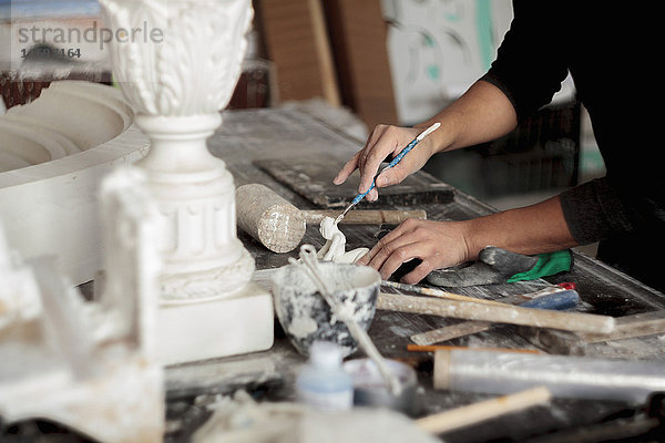 Kaukasischer Künstler beim Bildhauern mit Werkzeug