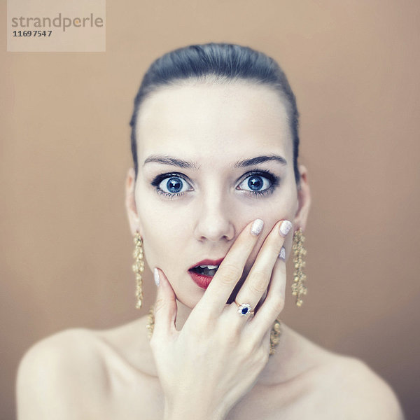 Porträt einer überraschten kaukasischen Frau mit Ohrringen