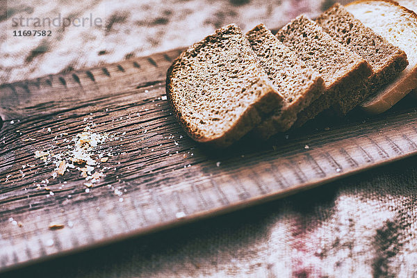 Nahaufnahme von Brotscheiben und Krümeln auf einem Holztablett