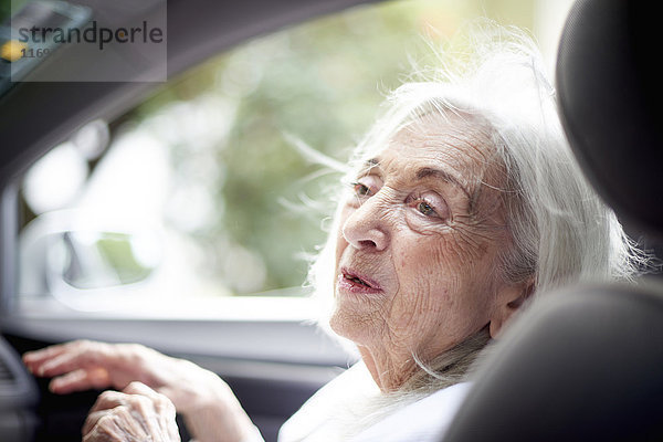 Ältere kaukasische Frau sitzt im Auto