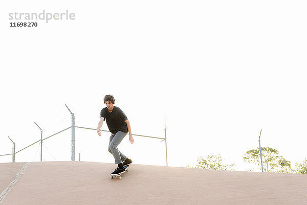Hispanischer Mann beim Skateboardfahren im Skatepark
