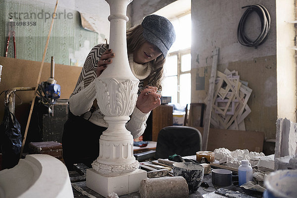 Kaukasischer Bildhauer beim Schnitzen eines Gipsstücks