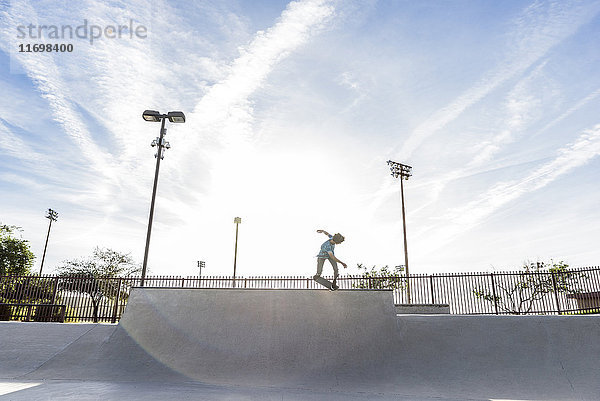 Hispanischer Mann fährt Skateboard im Skatepark