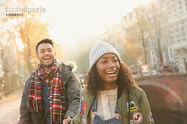 Lachendes junges Paar auf der urbanen Herbststraße  Amsterdam