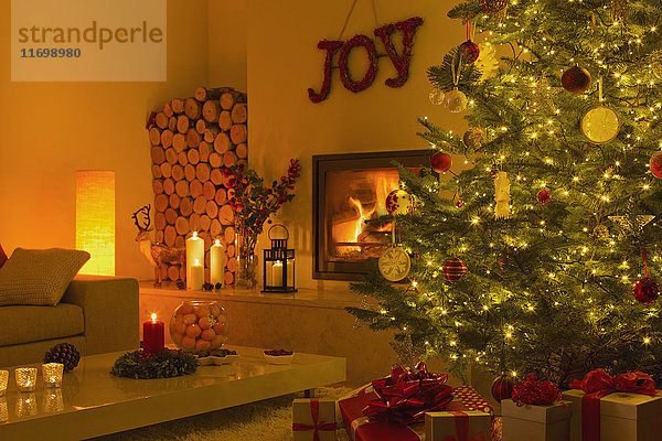 Stimmungsvoller Kamin und Kerzen im Wohnzimmer mit Weihnachtsbaum