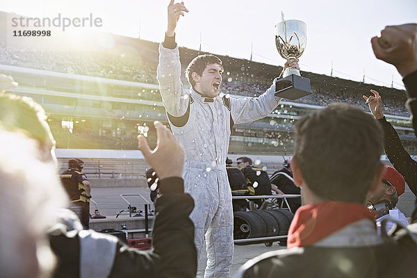Formel-1-Rennstall jubelt dem Fahrer mit Trophäe zu  feiert Sieg auf der Sportstrecke