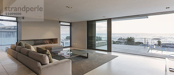 Modernes Luxus-Wohnzimmer mit Terrassentüren zum Meer und zur Terrasse