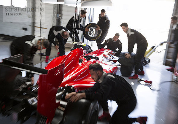 Boxencrew bei der Arbeit am Formel-1-Rennwagen in der Reparaturwerkstatt