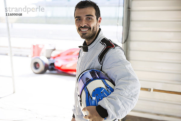 Porträt souveräner Formel-1-Rennwagenfahrer mit Helm in der Reparaturwerkstatt