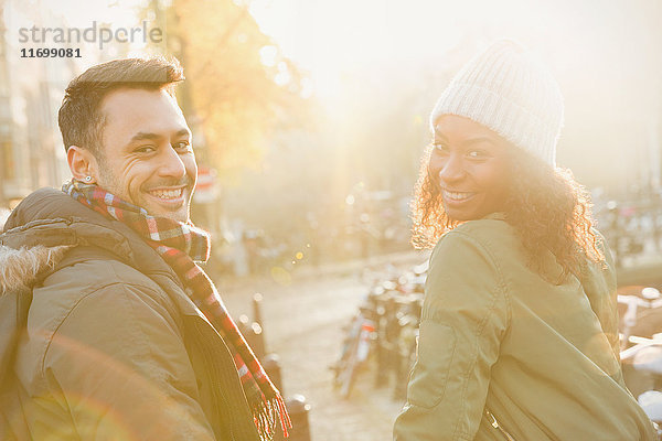 Portrait lächelndes junges Paar auf sonniger urbaner Herbststraße