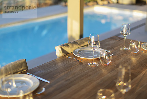 Platzierungen auf dem Terrassentisch aus Holz am Pool