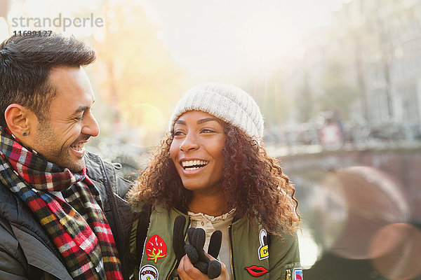 Lachendes junges Paar am Herbstkanal