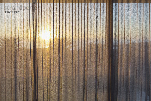 Ruhiger Sonnenuntergang hinter Gazevorhängen