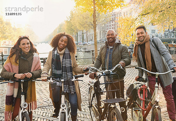 Portrait lächelnde Freunde Radfahren in der urbanen Herbststraße  Amsterdam