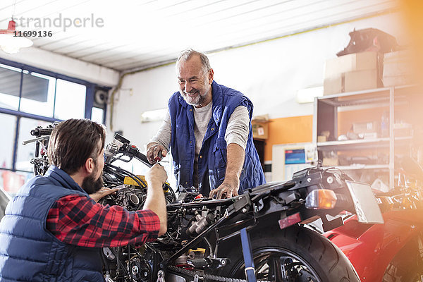 Motorradmechaniker beim Reparieren von Motorrädern in der Werkstatt