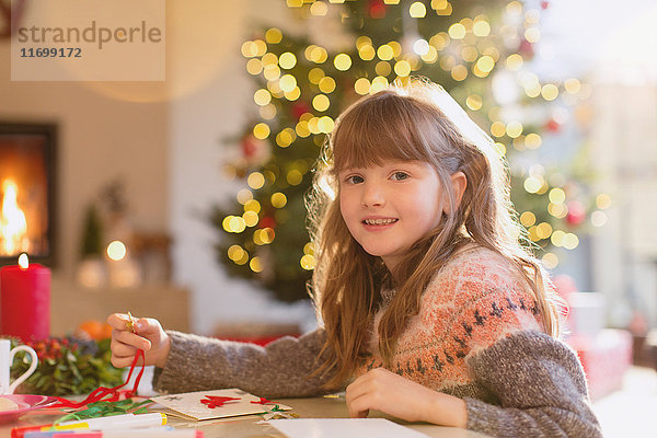 Porträt lächelndes Mädchen beim Basteln von Weihnachtsschmuck