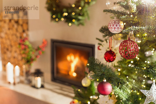 Roter und weißer Weihnachtsschmuck am Weihnachtsbaum neben dem Kamin