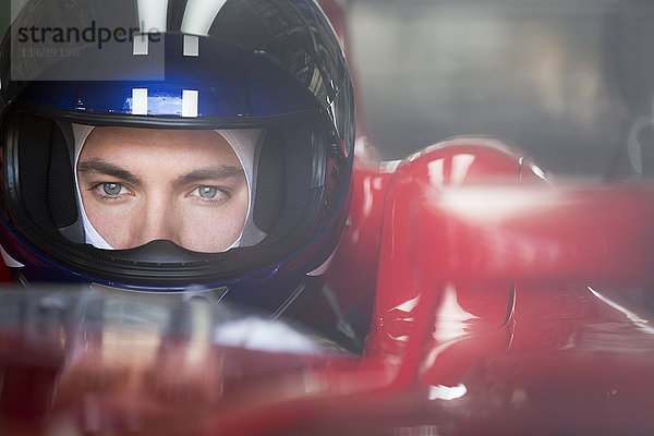 Nahaufnahme fokussierter Formel-1-Rennfahrer im Helm mit Blick in die Ferne