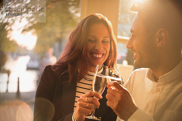 Lächelndes  romantisches Pärchen mit Champagnergläsern im Restaurant
