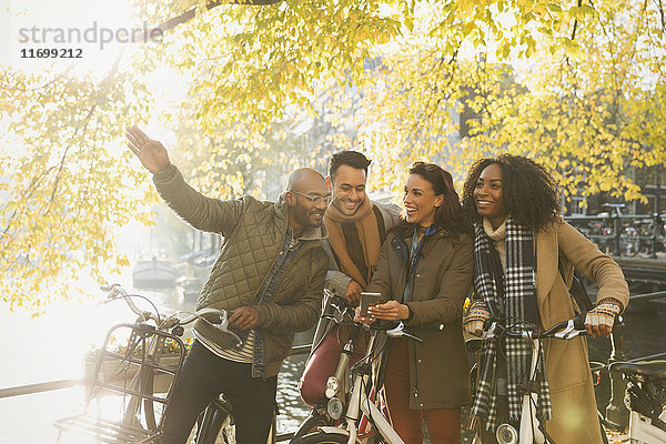Freunde mit Fahrrädern am sonnigen Herbstkanal