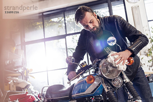 Motorradmechaniker beim Wischen von Motorrädern in der Werkstatt