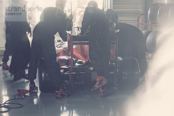 Boxencrew bei der Arbeit am Formel-1-Rennwagen in der Reparaturwerkstatt