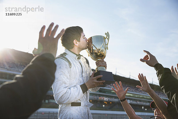 Formel-1-Rennstall jubelt um den Fahrer  küsst Trophäe  feiert Sieg