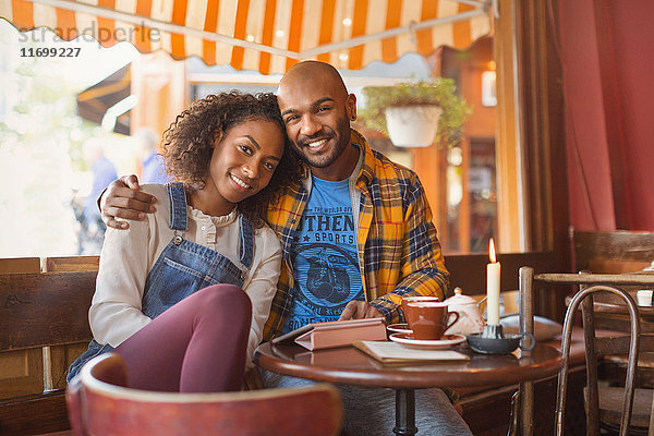 Portrait lächelndes  liebevolles junges Paar  das sich im Café umarmt.