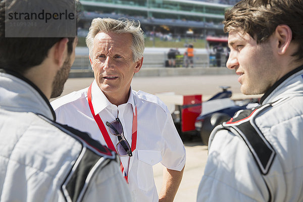 Manager im Gespräch mit Formel-1-Fahrern auf der Sportbahn